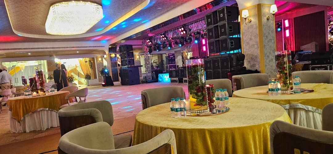The banquet hall with round tables laid beneath a large chandelier