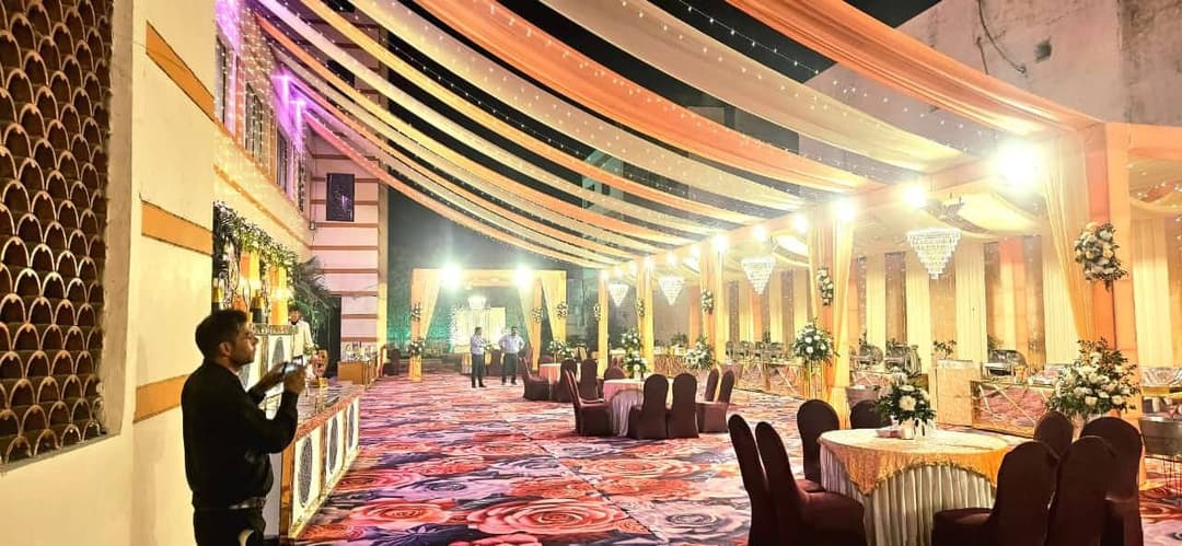 The covered lawn at night, lit by festoon lights above a seated function